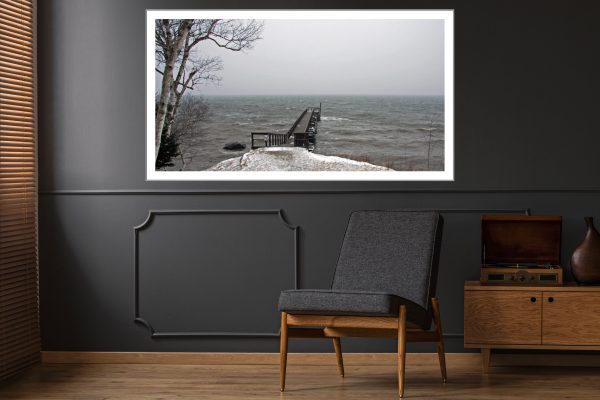 Snowy wooden pier in foggy water in North America